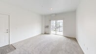 Located in Post Falls, Idaho, this well-designed one-bedroom, one-bathroom residence offers a thoughtful layout that maximizes comfort and functionality. The open-concept living area is finished with plush carpeting and crisp white walls, creating a bright, clean atmosphere. A sliding glass door leads to a private balcony, filling the space with natural light and providing views of the surrounding neighborhood.

The kitchen is a standout feature, equipped with rich dark cabinetry, stainless steel appliances including a refrigerator, range, and microwave, and light stone-look countertops that extend to a convenient breakfast bar — seamlessly connecting the kitchen to the living area. Wood-look flooring grounds the kitchen space with a warm, modern aesthetic.

The bedroom is a comfortable retreat, featuring plush carpeting, a large window dressed with vertical blinds that invite natural light, and a closet with sliding doors providing ample storage.

The bathroom is finished with a wide vanity topped with a marble-look countertop, dark cabinetry, a large mirror, and wood-look flooring, delivering a clean, contemporary feel. Throughout the residence, neutral tones and modern finishes create a cohesive and inviting living environment.