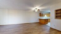 Located at 955 Vadnais Dr in Vadnais Heights, MN, this two-bedroom, one-bathroom single-floor home offers a functional and comfortable layout. The open-concept living room and kitchen area is a central highlight, featuring warm hardwood-style flooring, a textured ceiling, and a ceiling fan with integrated light fixture that adds both style and practicality. The kitchen is well-equipped with oak cabinetry, white appliances including a range and refrigerator, a double sink, ample counter space, and tile flooring. A peninsula counter connects the kitchen to the living area, creating a seamless flow ideal for everyday living. Both bedrooms are carpeted and finished with warm neutral tones. The primary bedroom is generously sized, offering two closets with sliding doors and a ceiling fan with a large window allowing natural light. The second bedroom also includes a closet and a window with neighborhood views. The full bathroom features tile flooring, an oak vanity with storage, a wall mirror, and a tub/shower combination. Throughout the home, consistent wood-trimmed doors and warm neutral walls create a cohesive and inviting atmosphere.