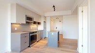 Located at 280 Montgomery Street in Ottawa's K1L neighbourhood, this well-appointed one-bedroom, one-bathroom unit offers a thoughtfully designed open-concept layout with modern finishes throughout. Light hardwood flooring runs continuously across the entire space, contributing to a bright and cohesive aesthetic.

The combined kitchen, dining, and living area forms the heart of the unit. The kitchen is outfitted with sleek grey cabinetry, a mosaic tile backsplash, stone countertops, and a full suite of stainless steel appliances including a range, over-the-range microwave, dishwasher, and refrigerator. A central island provides additional prep and dining space. Track lighting overhead adds a contemporary touch, while a large window floods the living area with natural light and offers open outdoor views.

The bedroom is a comfortable and serene space featuring mirrored sliding closet doors that enhance the sense of openness, along with a window that brings in additional natural light and views. Two closets provide ample storage throughout the unit.

Additional conveniences include an in-unit laundry area, a full bathroom, and a dedicated entrance. The clean white walls and minimalist design give the space a fresh, move-in-ready feel ideal for modern urban living.