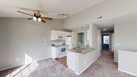 Located at 10125 Woodmont Way in Perrysburg, Ohio, this 2-bedroom, 1-bathroom single-floor residence offers a well-organized layout designed for comfortable everyday living. The open-concept kitchen and living area form the heart of the home, where the kitchen features white cabinetry, granite-style countertops, a peninsula with a sink, and white appliances including a range, microwave, refrigerator, and dishwasher. Wood-look flooring runs through the kitchen, while plush carpet extends into the living area. The living room is bright and airy, benefiting from multiple windows and a sliding glass door that invites natural light and outdoor views, complemented by a ceiling fan overhead. The spacious primary bedroom includes a dedicated closet and is finished with soft carpet flooring. The second bedroom also features carpet and a window with neighborhood views. The full bathroom is notably generous, offering a dual-sink vanity with granite-style countertops, a wide mirror, wood-look flooring, and a separate water closet. Three closets throughout the home provide ample storage, along with two utility rooms. The neutral gray color palette and clean finishes create a cohesive, move-in-ready atmosphere throughout.