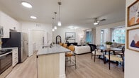 This single-floor residence on Fisher Street in Charlottesville, Virginia, presents a thoughtfully designed open-concept layout that seamlessly connects the kitchen, dining, and living areas. The kitchen is a standout feature, outfitted with light wood cabinetry, granite countertops, a white subway tile backsplash, and a full suite of stainless steel appliances. A central island with pendant lighting and bar seating serves as both a functional workspace and a casual gathering spot.

The living area flows naturally from the kitchen, featuring light wood-style flooring, a ceiling fan, and access to natural light through large windows and a glazed door. A dedicated dining space accommodates a full table and chairs, accented by hardwood-style flooring and modern wall décor.

The bedrooms are carpeted and well-lit by large windows that offer views of the surrounding exterior. Each bedroom is generously proportioned with ample wall space. The bathrooms are finished with granite-topped vanities, light wood cabinetry with matte black hardware, large mirrors, and glass-enclosed showers. Mirrored closet doors in the hallway enhance the sense of space. Throughout the residence, a neutral color palette and consistent finishes create a cohesive, contemporary ambiance.