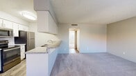 Located at 450 W Cool Dr in Oro Valley, AZ, this single-floor, 4-bedroom, 1-bathroom unit offers a practical and efficient layout. The open-concept living and kitchen area serves as the heart of the home, where wood-look flooring transitions seamlessly from the kitchen into the carpeted living space. A ceiling fan overhead and a front-facing window provide natural light and ventilation.

The kitchen is well-appointed with a galley-style design featuring white cabinetry, granite-style countertops, a stainless steel sink, and a full suite of stainless steel appliances including a refrigerator, electric range, built-in microwave, and dishwasher. A breakfast bar connects the kitchen to the living area, adding versatility to the space.

The four bedrooms are carpeted throughout and share a consistent neutral color palette with textured ceilings. Several rooms receive natural light through windows with blinds. The primary bedroom includes direct access to a dedicated closet and the shared bathroom, which features a dual-sink vanity with granite-style countertops, wood-look flooring, and a combined tub and shower. Additional closet storage is provided throughout the unit.