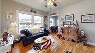 Located at 1017 London Rd in Duluth, Minnesota, this one-bedroom, two-bathroom residence offers a thoughtfully arranged single-floor layout that maximizes every inch of its compact footprint. Warm hardwood flooring flows throughout, lending continuity and character to the entire space.

The living room serves as the heart of the home, bathed in natural light through a generous set of windows that frame views of the surrounding Duluth cityscape. A ceiling fan overhead adds comfort, while the open sightlines connect seamlessly to the dining area and kitchen beyond.

The combined dining and kitchen area is both functional and stylish. Rich, dark wood cabinetry reaches toward the ceiling, paired with granite-style countertops and black appliances including a gas range and full-size refrigerator — providing ample storage and a well-equipped cooking space.

The bedroom is a comfortable retreat, featuring multiple windows that invite abundant natural light and city views. A standout feature is the elegant set of French doors with glass panes that open into a spacious closet, adding a distinctive architectural touch. Two closets in total offer generous storage throughout the home.

Two full bathrooms, including one with a tub-shower combination, complete the layout. A connecting hallway ties the rooms together efficiently, making this Duluth residence a practical and inviting space.
