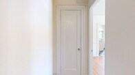 Located in the Westlake neighborhood of Los Angeles, this three-bedroom, one-bathroom unit on the third floor offers a thoughtfully laid-out single-level floor plan with timeless architectural character. Rich hardwood floors extend throughout the living areas and all three bedrooms, adding warmth and continuity to the space. The generously sized primary bedroom features a ceiling fan, natural light from a set of windows, and access to an adjacent vanity area, offering a touch of vintage charm. The additional bedrooms are well-proportioned, each with their own window for natural light, and one includes a classic cast-iron radiator. The kitchen retains its period character with white cabinetry featuring glass-front uppers, a classic double-basin sink with wall-mounted fixtures, subway tile backsplash, and a bold black-and-white checkered tile floor that extends into the connecting hallway. The bathroom continues the vintage aesthetic with full white subway tile walls, penny tile flooring, a pedestal sink, and a soaking tub beneath a bright window with a view of the surrounding greenery. Multiple hallways connect the rooms efficiently, and the overall palette of crisp white walls against warm wood floors gives the unit a clean, classic feel throughout.