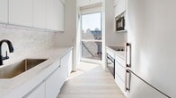 Located at 150 Roehampton Avenue in the heart of midtown Toronto, this well-appointed 2-bedroom, 2-bathroom unit offers a clean, contemporary design throughout. Light wood laminate flooring flows seamlessly across the entire space, complementing the bright white walls and creating a fresh, cohesive aesthetic.

The open-concept living area is bathed in natural light through expansive floor-to-ceiling windows and a glass door that opens to a private balcony, offering impressive views of the surrounding Toronto skyline. The galley-style kitchen features sleek white cabinetry, marble-look stone countertops with a matching backsplash, and stainless steel built-in appliances, including an oven, microwave, and cooktop — all illuminated by a large window with city views.

Both bedrooms are generously proportioned, with large windows framing panoramic urban vistas, including views of neighboring towers and green spaces below. The primary bedroom benefits from a spacious layout with ample closet storage. The unit includes five closets in total, providing excellent storage throughout.

Both bathrooms are finished in light tile with marble-look vanity countertops, modern matte black fixtures, and glass-enclosed tub-shower combinations, maintaining the unit's clean, minimalist character.