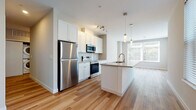 Located at 2826 Franklin Blvd in Cleveland's Ohio City neighborhood, this thoughtfully designed single-floor residence offers a clean, modern aesthetic throughout. The open-concept living and kitchen area serves as the heart of the home, featuring warm hardwood flooring, white shaker cabinetry, stainless steel appliances — including a refrigerator, range, and built-in microwave — and a central island with an undermount sink and pendant lighting overhead. Large windows flood the living area with natural light and provide views of the surrounding neighborhood. A dedicated laundry area with stacked washer and dryer units is conveniently tucked adjacent to the kitchen. The bedrooms are carpeted for comfort and benefit from generous natural light through multiple windows, giving each room a bright and airy feel. Two bathrooms mirror the home's modern design language, each outfitted with white shaker vanity cabinetry, undermount sinks, brushed nickel fixtures, and hardwood flooring. The consistent use of neutral tones, clean lines, and quality finishes throughout creates a cohesive and contemporary living environment well-suited for everyday comfort.
