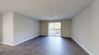 Located at 2208 Yager Creek Dr in Charlotte, NC, this single-floor home offers four bedrooms, two full bathrooms, and a thoughtfully arranged layout. The open living room is a welcoming centerpiece, featuring durable hardwood-style flooring, neutral wall tones, and a textured ceiling. A sliding glass door with vertical blinds leads to a private balcony overlooking lush greenery, filling the space with natural light. The kitchen is well-appointed with white cabinetry, light quartz-style countertops, a double-basin sink, and stainless steel appliances including a refrigerator, range, and dishwasher. Light wood-look tile flooring completes the clean, functional look. The bedrooms are carpeted for comfort, each featuring neutral tones and windows that bring in natural light. The primary bedroom is generously sized and connects to a walk-in closet equipped with wire shelving. The bathrooms are finished with wood-look tile flooring, light countertops, and tub-shower combinations. A dedicated laundry room includes side-by-side washer and dryer units with overhead wire shelving for added storage. A central hallway connects all rooms, providing a practical and efficient flow throughout the home.