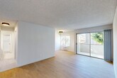 Located in the desirable West Los Angeles neighborhood of 90025, this 3-bedroom, 2-bathroom residence offers a well-organized single-floor layout with a clean, modern aesthetic throughout. Light wood flooring runs continuously across the living spaces, complemented by crisp white walls and textured ceilings that lend a bright, airy feel.

The open living room is a welcoming centerpiece, featuring a sliding glass door that opens to a private balcony with views of mature greenery, along with an additional window that draws in generous natural light. The adjacent kitchen is thoughtfully appointed with white cabinetry, granite countertops, a stainless sink, and black appliances including a range and microwave. A stacked in-unit washer and dryer adds everyday convenience.

The spacious primary bedroom offers a comfortable retreat, while two additional bedrooms each feature large windows overlooking lush outdoor foliage. Both bathrooms are finished with granite vanity counters and light tile flooring; one includes a sleek glass-enclosed tub-shower combination, while the other features a full tub with shower. A dedicated closet and hallway complete the functional floor plan, making this a practical and inviting home in a prime Los Angeles location.