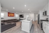 Located near the University of Southern California at 2652 Ellendale Pl, Los Angeles, this thoughtfully renovated single-story home offers five bedrooms and three bathrooms across a well-organized floor plan. Light wood-style flooring runs throughout, lending a clean, cohesive look to every room.

The open kitchen is a standout feature, showcasing quartz countertops with marble-like veining, crisp white shaker cabinetry, stainless steel appliances including a gas range, microwave, and refrigerator, and a large center island with bar seating. A stacked washer and dryer unit is conveniently located just off the kitchen. The adjacent living room provides a comfortable gathering space with recessed lighting and a wall-mounted mini-split climate control unit.

Each bedroom is finished with the same light flooring, neutral walls, and individual windows that bring in natural light and neighborhood views. The rooms are efficiently sized, with the primary bedroom offering a comfortable retreat. Bedrooms are equipped with mini-split units for personalized climate control.

The three bathrooms are finished in a clean, modern style with white subway tile, quartz-topped vanities, and chrome fixtures. Bathing options include both a tub-shower combination and a frameless glass walk-in shower. The overall design is bright, functional, and well-suited for shared living near campus.