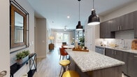 This thoughtfully designed one-bedroom, one-bathroom residence in Tucker, Georgia offers a seamless open-concept floor plan that connects the kitchen, dining, and living areas into one cohesive, light-filled space. The kitchen is a standout feature, showcasing rich dark cabinetry, a classic subway tile backsplash, granite countertops, stainless steel appliances, and a central island with pendant lighting — ideal for both everyday cooking and casual entertaining. Light wood-style flooring flows throughout the main living areas, enhancing the bright and airy ambiance. The living room exudes a warm, inviting character, anchored by a bold accent wall, a ceiling fan, and large windows that draw in natural light and offer views of the balcony beyond. The bedroom is a serene retreat, featuring plush carpeting, a striking deep green accent wall, and a spacious walk-in closet with built-in shelving. The full bathroom is finished with granite-topped dark vanity cabinetry, wood-style flooring, and a soaking tub. Recessed lighting throughout and a well-considered layout make this unit a comfortable and functional single-floor living space in the heart of Tucker.