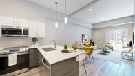 Located at 425 Ballantrae Drive in Winnipeg, this well-appointed 2-bedroom, 2-bathroom unit offers a thoughtfully designed single-floor layout. The open-concept kitchen and living area serves as the heart of the home, where a modern kitchen impresses with two-tone cabinetry — white uppers paired with dark lower cabinets — stainless steel appliances, a subway tile backsplash, white quartz countertops, and a peninsula with pendant lighting overhead. Light wood-style flooring runs throughout the main living areas, enhancing the bright, airy atmosphere. The living room is generously proportioned, featuring elevated ceilings, a sliding glass door that opens onto a private balcony with views of the surrounding multi-storey development, and ample natural light. The primary bedroom offers a comfortable retreat, complete with a closet featuring stylish sliding glass-panel doors, carpeted flooring, and convenient access to an in-unit laundry area. Both bathrooms are finished in a clean, contemporary style with white vanities, stone-look tile flooring, and full tub-shower combinations. A connecting hallway ties all spaces together efficiently. The unit presents a cohesive modern aesthetic throughout, making it a functional and attractive urban residence.