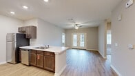 Located at 391 Cross Creek Rd in Central, SC, this single-story 4-bedroom, 2-bathroom home offers a well-designed layout with modern finishes throughout. The open-concept kitchen and living area serves as the heart of the home, featuring rich dark-stained cabinetry, light marble-style countertops, a peninsula with an integrated sink, and stainless steel appliances including a range, microwave, and refrigerator. Light wood-look flooring runs through the main living areas, complementing the neutral color palette. The living room is bright and welcoming, highlighted by a ceiling fan and French doors that open to an outdoor space, allowing natural light to flow in. The four bedrooms offer plush carpet flooring and generous wall space, with the primary bedroom providing a comfortable and sizable retreat. The two bathrooms are finished with wood-tone vanities, light countertops, and wood-look flooring; one bathroom includes a shower-tub combo with grab bars and a window for natural light. A dedicated laundry room with washer/dryer hookups, overhead wire shelving, and hardwood-style flooring adds everyday convenience to this functional and move-in ready home.