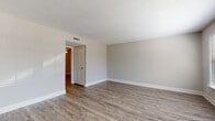 This two-story home offers a thoughtfully designed layout with a blend of practical finishes and comfortable living spaces throughout. The main level welcomes you through a paneled front door into a bright, open living area with durable wood-style flooring, neutral-toned walls, and a textured ceiling. Crown molding and a ceiling fan with light fixture add character to the main living and dining areas, which flow seamlessly together. A staircase with white balusters leads to the upper level.

The kitchen is well-appointed with white raised-panel cabinetry, granite-style countertops, and a full suite of black and stainless appliances including a refrigerator, electric range, and dishwasher. Wood-style flooring continues throughout the kitchen.

Upstairs, the bedrooms feature plush carpeting and large windows fitted with blinds that allow ample natural light and outdoor views. The primary bedroom includes a walk-in closet and a private en-suite bathroom. Both bathrooms are finished with white cabinetry, granite-style countertops, tub/shower combos, and wood-style flooring, providing a clean and cohesive aesthetic. The home's neutral palette and consistent finishes create a move-in ready, welcoming atmosphere throughout.