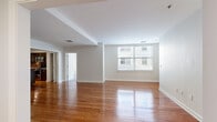 Located in the Manhattan 15 community in Memphis, TN, this well-appointed residence offers four bedrooms, four bathrooms, and a thoughtfully designed single-floor layout. The expansive living room is highlighted by rich, polished hardwood floors that reflect natural light streaming through large windows, creating a bright and welcoming atmosphere set against clean, neutral-toned walls.

The space features two kitchens, each equipped with dark espresso cabinetry with frosted glass accents, granite countertops, stainless steel appliances, a subway tile backsplash, and a central island with pendant lighting — ideal for both everyday living and entertaining. An in-unit laundry room provides added convenience with a full-size front-loading washer.

The bedrooms offer plush carpeting, ceiling fans, and generous natural light from well-placed windows. Each bedroom is complemented by its own closet, featuring wire shelving systems for organized storage. The primary bedroom is notably spacious, providing ample room for comfortable furnishings.

The four bathrooms are finished with neutral travertine-style tile, soaking tubs, and vanities with granite countertops and frosted glass cabinetry details that echo the kitchen's design language. A connecting hallway ties all areas together for a cohesive and functional flow throughout the home.