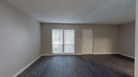 This single-floor residence offers a thoughtfully designed layout with a clean, modern aesthetic throughout. The open living area features dark hardwood-style flooring and a textured ceiling, with a sliding glass door that fills the space with natural light and provides access to the outdoors. Adjacent to the living area, a dedicated dining space is highlighted by a stylish pendant light overhead.

The kitchen is well-equipped with crisp white shaker-style cabinetry, granite countertops, a classic subway tile backsplash, a stainless steel sink, and stainless steel appliances including a range and dishwasher — offering both functionality and visual appeal.

The bedrooms are carpeted for comfort and warmth, each featuring windows with blinds that allow natural light while maintaining privacy. The primary bedroom includes a spacious walk-in closet with built-in shelving, providing ample storage. 

The bathrooms are finished with consistent hardwood-style flooring, granite-topped vanities with white cabinetry, and brushed nickel fixtures. One bathroom features a full tub-shower combination, while a separate water closet adds convenience. Neutral wall tones and clean white trim unify the space, creating a cohesive and inviting atmosphere throughout.