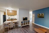 Located at 515 Sycamore Ln in Davis, CA, this 2-bedroom, 2-bathroom single-floor unit offers a well-organized layout that maximizes every square foot. The living room greets you with rich hardwood-style flooring and a striking teal accent wall, creating a vibrant yet welcoming atmosphere. A front-facing window fills the space with natural light and provides views of the surrounding neighborhood. The kitchen flows directly into the dining and living areas, featuring warm oak cabinetry, light countertops, and a dark refrigerator, making it a functional and connected space for everyday living. The primary bedroom is carpeted and well-proportioned, offering a quiet retreat. The second bedroom also features carpet flooring, a mirrored sliding-door closet, a dedicated workspace, and a window with outdoor views — ideal for study or rest. The two bathrooms are clean and practical: one includes a double-sink vanity with oak cabinetry and a large mirror, while the other is a compact full bath with a tub-shower combination and wood-look flooring. A connecting hallway ties all rooms together efficiently. Textured ceilings are consistent throughout the unit, adding a classic residential feel to this functional Davis home.