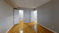 Located at 1 Dean Park Rd in Toronto's east end, this 2-bedroom, 1-bathroom residence offers a practical and comfortable single-floor layout. Throughout the living areas and bedrooms, warm parquet hardwood flooring adds a classic character, complemented by neutral grey walls and white baseboards that create a clean, cohesive aesthetic. Textured ceilings are present throughout the unit.

The kitchen is bright and functional, featuring white cabinetry with modern bar-pull hardware, marble-look countertops, a stainless steel sink, and full-size appliances including a stove and refrigerator. White tile flooring ties the space together neatly.

The primary bedroom is a well-proportioned room with a window that brings in natural light, while the second bedroom includes a sliding double closet and its own window. Both rooms offer a calm, neutral atmosphere. The hallway connects the rooms efficiently and includes an additional closet for storage.

The bathroom is finished in crisp white, featuring a full soaker tub with an overhead shower and white subway-style wall tiles paired with chrome fixtures.

A balcony extends the living space outdoors, providing a private area to enjoy the surroundings. The overall layout is thoughtfully organized, making this a comfortable and functional residence in a well-established Toronto neighbourhood.