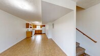 Located at 101 Embassy Ct in Muldraugh, Kentucky, this two-story, two-bedroom, two-bathroom unit offers a practical and well-organized layout across two evenly distributed floors. The main level opens into a combined dining and living area, creating a comfortable shared space anchored by light-toned tile flooring. The kitchen is efficiently designed in an L-shaped configuration, featuring warm oak cabinetry with ample upper and lower storage, light countertops, a white electric range, dishwasher, refrigerator, and a window that brings in natural light. A bathroom on this level includes a vanity with wood cabinetry and tile flooring. The upper floor houses both bedrooms, each finished with neutral wall-to-wall carpeting and individual closets with built-in shelving. The bedrooms receive natural light through windows with views of surrounding greenery. A full bathroom on this floor includes a tub-shower combination. Additional highlights include four closets throughout for generous storage, an in-unit laundry area, and two staircases connecting the floors. The clean, white walls and consistent finishes throughout give the space a simple, functional character well-suited for everyday living.