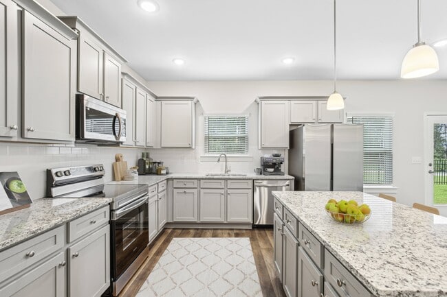 Spacious kitchen with an island, ample storage, stainless steel appliances and view into the living room. - Southwind