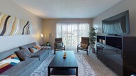 This single-floor residence at 1308 Camp Hill Way in West Carrollton, Ohio offers a well-organized and functional layout designed for comfortable everyday living. The living room is a welcoming space featuring sliding glass doors that flood the room with natural light and provide direct access to a private outdoor area, offering views of the surrounding neighborhood. Neutral-toned walls and carpet create a warm, inviting atmosphere throughout.

The galley-style kitchen is efficiently designed with warm wood cabinetry, granite-toned countertops, hardwood-style flooring, and a full suite of black appliances including a refrigerator, range, microwave, and dishwasher. Adjacent to the kitchen, the dining area continues the hardwood-style flooring and offers a bright, open space ideal for everyday meals.

The residence features multiple bedrooms, each carpeted and finished with neutral walls. The primary bedroom includes an en-suite bathroom with a shower/tub combination, while additional bedrooms offer ample natural light through large windows. A full bathroom with hardwood-style flooring, a vanity, and a tub-shower combo serves the remaining rooms. Closet storage is available throughout, rounding out a practical and comfortable living environment.