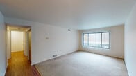 Located at 3510 N Drake Rd in Kalamazoo, Michigan, this single-floor unit offers a practical and comfortable layout designed for everyday living. The spacious living area features neutral-toned carpet and a large window with vertical blinds that allows for generous natural light. A transition zone connects the carpeted living space to wood-look flooring that carries through the remainder of the unit, creating a clear distinction between areas. A ceiling fan overhead adds both function and airflow to the adjoining open space.

The kitchen is well-appointed with warm oak cabinetry offering ample storage above and below the counters, light-toned countertops, and a double-basin sink. White appliances — including a range, dishwasher, and refrigerator — are included, and the wood-look flooring continues throughout, giving the kitchen a cohesive, clean appearance.

The bedroom is a quiet, carpeted retreat with a window providing natural light and a sliding wood-panel closet door for storage. A hallway connects the bedroom to the full bathroom, which features white square tile flooring, a tub-shower combination with tiled surround, a toilet, and a vanity with a wood-tone cabinet. The overall aesthetic throughout the unit is clean, neutral, and move-in ready.