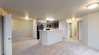 Located at 574 West Mogul Loop in Hayden, Idaho, this single-floor home offers a practical and comfortable layout designed for everyday living. The open-concept kitchen and living area serves as the heart of the home, where a peninsula with light countertops creates a natural divide between the two spaces. The kitchen is well-equipped with dark espresso cabinetry, light countertops, black appliances including a refrigerator, electric range, and over-the-range microwave, and durable light wood-style flooring. The adjacent living area features plush neutral carpeting that extends throughout the bedrooms. Each bedroom is generously sized, with large windows that invite natural light and provide views of the surrounding neighborhood. Ceiling fans are featured in select bedrooms, adding comfort and functionality. Closet space is ample, with walk-in style storage visible in multiple rooms. The bathrooms are clean and functional — one features a full tub and shower combination with chrome fixtures, while another includes a single-sink vanity with dark cabinetry, a large mirror, and wood-style flooring. The overall aesthetic is neutral and move-in ready, with a consistent color palette of soft grays and beiges throughout.