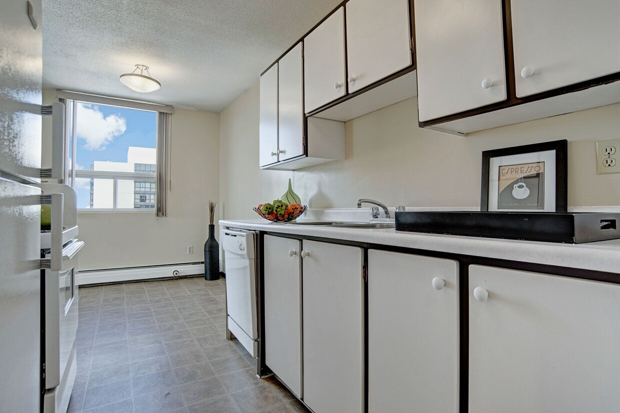 A kitchen with white appliances and white cabinetry - Marquis Towers