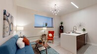 This single-floor unit showcases a cohesive mid-century modern design throughout its well-organized layout. The open-concept living area flows naturally into the kitchen, creating a spacious and functional common space. The living room features neutral carpet flooring, tall walls painted in a soft warm tone, and a statement sputnik chandelier overhead, complemented by a window fitted with modern cellular shades that allow for controlled natural light.

The kitchen is outfitted with rich walnut-toned cabinetry, stainless steel appliances including a refrigerator, range, and microwave, and a teal mosaic tile backsplash that adds a vibrant accent. A white peninsula with an integrated sink provides additional prep space and casual dining.

Two bedrooms offer comfortable retreats, each with plush carpet flooring and ample closet space. The bathroom is notably well-appointed, featuring a walk-in shower tiled in deep teal subway tile, a floating walnut vanity with a white countertop, and a warm wood-framed mirror.

A dedicated laundry closet houses a full-size front-loading washer and dryer alongside the water heater and HVAC unit, maximizing the practicality of the space. The overall ambiance is modern, clean, and thoughtfully designed.