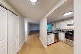 Located at 330 Palace Ct in North Syracuse, NY, this single-floor, 2-bedroom unit offers a practical and well-organized layout with consistent light wood flooring throughout. The open-concept design connects the kitchen and living areas seamlessly. The kitchen is a standout feature, equipped with white shaker-style cabinetry, bold dark granite countertops, stainless steel appliances including a refrigerator and range, and an under-mount sink — all centered around a peninsula that opens to the living area. Natural light filters into the living space through a window overlooking lush greenery, creating a bright and welcoming ambiance. Both bedrooms are comfortably sized, each featuring windows with blinds that invite natural light and offer outdoor views. The primary bedroom includes a dedicated closet, and the unit overall boasts four closets, providing generous storage. Baseboard heating is present throughout the bedrooms and living spaces, and a wall AC unit ensures year-round comfort. The neutral, light-toned walls complement the clean, modern aesthetic of the space, making it a versatile and functional home.