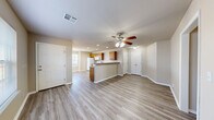 Located at 2982 Creekside Dr in Catoosa, Oklahoma, this single-story 2-bedroom, 2-bathroom home offers a practical and well-organized layout. The open-concept living room and kitchen form the heart of the home, unified by light-toned wood-look vinyl flooring that extends throughout the entire space. A ceiling fan with integrated lighting anchors the living area, which flows naturally into the kitchen. The kitchen features warm honey-toned wood cabinetry, a tile backsplash, a peninsula breakfast bar, recessed lighting, and white appliances including a refrigerator, electric range, and built-in microwave. Both bedrooms are comfortably proportioned, with the primary bedroom offering a ceiling fan, a window for natural light, and direct access to a hallway. The second bedroom also includes a ceiling fan and window. Each bathroom is equipped with wood-toned cabinetry, a tub-shower combination, and matching wood-look flooring. A dedicated closet and hallway connect the private areas of the home efficiently. Neutral warm beige walls throughout create a cohesive and inviting atmosphere, while consistent flooring and clean white trim give the home a polished, move-in-ready appearance.