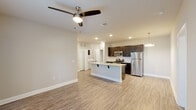 This single-floor residence offers a clean, contemporary design with a thoughtful open-concept layout. The kitchen serves as a central highlight, featuring dark espresso cabinetry, stainless steel appliances including a gas range, microwave, and refrigerator, complemented by a large granite-topped island with an undermount sink and pendant lighting overhead. The kitchen flows seamlessly into a spacious living area finished with light wood-look luxury vinyl plank flooring that extends throughout the unit, creating a cohesive and easy-to-maintain aesthetic.

The bedrooms are well-proportioned, each equipped with ceiling fans, natural light from windows fitted with blinds, and access to closet storage. The neutral warm-gray wall tones provide a versatile backdrop throughout the space.

The bathrooms are finished to a consistent standard, with one featuring a double-sink granite vanity with dark cabinetry, a large mirror, and a walk-in shower. Another bathroom offers a full tub-shower combo with built-in shelving and open linen storage nearby. A dedicated laundry area is also present within the unit. Recessed lighting throughout ensures bright, even illumination in every room, contributing to the unit's modern and polished overall ambiance.