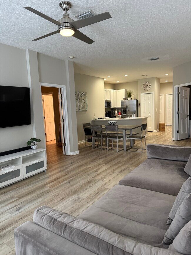 Sala de estar con vista al comedor y la cocina. - 9410 Georgian Park Ln