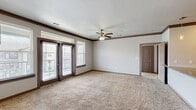 Located in Humble, TX, this single-story 2-bedroom, 2-bathroom residence offers a thoughtfully designed layout with quality finishes throughout. The open kitchen and living area serve as the heart of the home, where rich dark cabinetry pairs with granite countertops, a subway tile backsplash, and a full suite of stainless steel appliances, including a refrigerator, range, microwave, and dishwasher. Wood-style flooring runs through the kitchen and wet areas, while plush carpeting adds comfort to the living room and bedrooms. The living room features crown molding, a ceiling fan, and access to a private balcony through glass doors flanked by windows that invite natural light. The spacious primary bedroom includes built-in shelving and a walk-in closet with rod and shelf systems. Both bathrooms are finished with granite-topped dark vanities and full tub-shower combinations with white tile surrounds. The second bedroom offers carpeted flooring, a ceiling fan, and a window with exterior views. A dedicated laundry room accommodates a full-size washer and dryer. The hallway connects all rooms efficiently, completing a functional and cohesive floor plan well-suited for comfortable everyday living.
