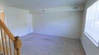 This two-floor space offers a straightforward and functional layout with a clean, neutral aesthetic throughout. The interiors are finished with soft, light-toned carpeting that adds warmth underfoot, while the walls are painted in a crisp, off-white hue that creates a bright and airy atmosphere. Visible HVAC vents are thoughtfully integrated into both the ceiling and lower wall areas, ensuring efficient climate control throughout the space. White baseboards frame the floors neatly, contributing to the tidy, well-maintained appearance of each room. The doors are finished in white, maintaining a cohesive and understated design palette. The open layout of the main living areas provides a generous sense of space, allowing for flexible furniture arrangements to suit a variety of needs. Spread across two floors, the layout offers natural separation between living and private areas, adding to the overall functionality of the home. The overall ambiance is calm and move-in ready, with a neutral canvas that lends itself well to personalization and a wide range of interior design styles.