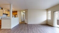 Located at 14602 Main St, Unit Y305 in Mill Creek, WA, this 3-bedroom, 2-bathroom apartment spans 1,160 square feet across a single floor. Wood-style flooring runs throughout the unit, providing a cohesive aesthetic from room to room.

The living room serves as a central gathering space, featuring a fireplace with an arched built-in surround above and sliding glass doors that open to a private balcony with views of the surrounding community. The kitchen is equipped with light maple cabinetry, white countertops, stainless steel appliances including a full-size refrigerator, and a gas range. A peninsula divides the kitchen from the hallway, which connects the remaining rooms.

Three bedrooms offer comfortable accommodations, including a 180-square-foot primary bedroom with an en-suite bathroom featuring a soaking tub, single-sink vanity with maple cabinetry, and wood-style flooring. The second bathroom includes a single-sink vanity with matching cabinetry. Secondary bedrooms include bifold closets with built-in shelving and large windows providing natural light. A dedicated laundry room accommodates a full-size washer and dryer with wire shelving above.