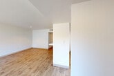 This well-organized single-floor residence features 2 bedrooms and 1 bathroom across a thoughtfully arranged layout. The combined dining and living area serves as the heart of the home, finished with light wood-tone flooring and a textured ceiling. Large sliding glass doors open directly onto a balcony, flooding the space with natural light and offering pleasant views of surrounding greenery and the neighborhood beyond. A half-wall partition subtly separates the living area from the adjacent spaces, adding architectural definition without sacrificing openness. The kitchen is designed for efficiency, featuring white cabinetry, dark granite-style countertops, a stainless steel sink, and a full-size refrigerator, all set on matching light wood flooring. The bedrooms are carpeted for comfort, with the primary bedroom offering a generous footprint, a wide double-door closet, and a window with views of mature trees. The bathroom includes a tiled shower-tub combination with decorative accent tiles and tile flooring. With five closets distributed throughout, storage is abundant. The entrance and hallway connect all areas smoothly, creating a cohesive and practical flow throughout the residence.