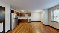 Located at 1990 Ford Drive in Cleveland's 44106 zip code, this one-bedroom, one-bathroom unit offers a practical and well-appointed single-floor layout. The open-concept kitchen and living area serves as the heart of the unit, featuring warm hardwood flooring, rich walnut-toned cabinetry, and a full suite of stainless steel appliances including a gas range, built-in microwave, refrigerator, and dishwasher. The kitchen flows seamlessly into the living space, creating a versatile area for both dining and relaxation. A hallway connects the main living zone to the private quarters, which include two closets and a utility room for added storage and convenience. The spacious primary bedroom is finished with plush carpeting and features a window that brings in natural light and neighborhood views. A second carpeted room, also with a window, offers flexibility as an additional bedroom or office space. The bathroom includes a full soaking tub with classic white tile surround and a window for ventilation. Throughout the unit, clean white walls, dark baseboards, and consistent flooring choices lend a cohesive, modern feel. Ceiling-mounted light fixtures illuminate each room effectively, completing this functional and comfortable Cleveland residence.