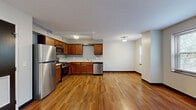 Located at 1990 Ford Drive in Cleveland's 44106 zip code, this one-bedroom, one-bathroom unit offers a practical and well-appointed single-floor layout. The open-concept kitchen and living area serves as the heart of the unit, featuring warm hardwood flooring, rich walnut-toned cabinetry, and a full suite of stainless steel appliances including a gas range, built-in microwave, refrigerator, and dishwasher. The kitchen flows seamlessly into the living space, creating a versatile area for both dining and relaxation. A hallway connects the main living zone to the private quarters, which include two closets and a utility room for added storage and convenience. The spacious primary bedroom is finished with plush carpeting and features a window that brings in natural light and neighborhood views. A second carpeted room, also with a window, offers flexibility as an additional bedroom or office space. The bathroom includes a full soaking tub with classic white tile surround and a window for ventilation. Throughout the unit, clean white walls, dark baseboards, and consistent flooring choices lend a cohesive, modern feel. Ceiling-mounted light fixtures illuminate each room effectively, completing this functional and comfortable Cleveland residence.