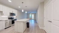 Located at 7350 Honore Ave in Sarasota, FL, this thoughtfully designed one-bedroom, one-bathroom residence offers a clean, contemporary aesthetic throughout. Light-toned wood-style flooring flows seamlessly across the entire unit, creating a cohesive and airy feel.

The open-concept kitchen and living area serves as the heart of the home. The kitchen is outfitted with white cabinetry extending to the ceiling, stainless steel appliances including a French door refrigerator, electric range, and microwave, as well as a granite-topped island with pendant lighting — ideal for both meal prep and casual dining.

The living area is bright and spacious, benefiting from a ceiling fan and direct access to a private balcony through a glass-paneled door, bringing in natural light and outdoor views of the surrounding greenery.

The generously sized bedroom features a ceiling fan, a large window with views of the outdoors, and access to two closets — including a walk-in closet equipped with wire shelving systems for ample organization.

The bathroom is clean and modern, featuring a granite-top vanity with under-mount sink, a glass-enclosed shower, and light wood-style tile flooring. A dedicated laundry area adds everyday convenience. The unit also includes recessed lighting throughout, completing this well-appointed Sarasota residence.