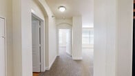 Located at 75 Riverfront Dr in North Little Rock, Arkansas, this one-bedroom, one-bathroom residence offers a thoughtfully designed single-floor layout that makes efficient use of its space. The living room is bright and open, featuring plush carpeting, a ceiling fan, track lighting, and a pass-through window that connects to the kitchen — a functional detail that enhances the open feel of the home. Built-in shelving with an arched accent provides both storage and a decorative focal point, while large windows invite generous natural light.

The kitchen is equipped with warm wood cabinetry, granite countertops, hardwood-style flooring, and a black dishwasher. A utility area is conveniently accessible from the kitchen.

The hallway is distinguished by elegant arched doorways and flush-mount lighting, lending a refined architectural character throughout. The bedroom is comfortably sized, featuring carpet flooring, a ceiling fan, and a bright window with blinds.

The bathroom includes tile flooring, a rich red vanity with granite countertops, and a separate bathing area with a window. The walk-in closet offers ample wire shelving and hanging rods across multiple walls, providing excellent storage capacity.
