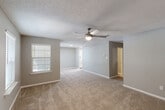Located in Baton Rouge, Louisiana, this 2-bedroom, 1-bathroom single-story home offers a practical and comfortable layout. The open living area is carpeted and features a ceiling fan with light, a textured ceiling, and windows with blinds that allow natural light to fill the space. The neutral gray-toned walls create a clean, cohesive aesthetic throughout the home.

The two bedrooms are carpeted and share a similar design, each equipped with a ceiling fan and window with blinds. The primary bedroom is a comfortable size and includes access to a walk-in closet outfitted with dual wire shelving racks, providing ample storage. The second bedroom offers a cozy, versatile space suitable for various uses.

The bathroom is well-appointed with a full tub-shower combination featuring a white surround and brushed nickel fixtures, complemented by tile flooring and warm neutral walls.

A connecting hallway ties the rooms together, contributing to the home's efficient flow. Throughout the space, plush carpeting, consistent neutral tones, and ceiling fans in each main room lend a cohesive and move-in-ready feel. The layout, as visible in the dollhouse view, is compact yet thoughtfully arranged to maximize the use of available space.