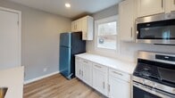 Located at 265 Seneca Dr in Syracuse, NY, this freshly renovated single-floor home offers a clean, modern aesthetic throughout. The interior is unified by light-toned luxury vinyl plank flooring and a soft neutral gray color palette, creating a bright and cohesive atmosphere from room to room.

The open-concept living and dining area is airy and well-lit, benefiting from large windows that invite natural light and offer views of the surrounding neighborhood. Recessed lighting adds a contemporary touch to the space. A white kitchen island with a pendant light and undermount sink anchors the kitchen, which is outfitted with crisp white shaker cabinets, white countertops, a stainless steel range, and a full-size refrigerator. A window above the counter adds additional natural light to the cooking space.

The bedrooms are generously proportioned and well-appointed, with neutral walls, recessed lighting, and ample closet space. One bedroom features dual windows on adjacent walls, flooding the room with natural light and views of the outdoors.

The bathroom is a standout feature, finished with large-format marble-look tile on both the floors and walls, including a fully tiled tub surround. A floating vanity with a vessel sink, a large mirror, and a window complete this refined space. The overall design reflects thoughtful, move-in-ready renovations throughout.