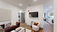 Located at 2200 Alpha Dr in Bridgeville, PA, this thoughtfully designed 2-bedroom, 2-bathroom residence offers a comfortable and functional single-floor layout. Warm hardwood-style flooring flows throughout, complemented by crisp white walls and recessed lighting that create a bright, contemporary atmosphere.

The open-concept living, dining, and kitchen area forms the heart of the home. The living room features a wall-mounted TV area and access to a private balcony through expansive floor-to-ceiling sliding glass doors, flooding the space with natural light and outdoor views. The kitchen is outfitted with white shaker cabinetry, stainless steel appliances including a side-by-side refrigerator and range, a herringbone tile backsplash, and a deep sink — offering both style and practicality.

The primary bedroom is a well-sized private retreat with room for a queen or king suite, while the second bedroom provides flexible living space. Both bathrooms are finished cleanly in white, with one featuring a full soaking tub and shower combination with matte black fixtures. A dedicated laundry room houses a full-size washer and dryer. A closet provides additional storage. The overall design balances modern aesthetics with everyday functionality.