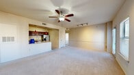 Located at 9201 Riverside Pkwy in Tulsa, Oklahoma, this single-story residence offers four bedrooms, three bathrooms, and a practical, well-organized floor plan. The open-concept living room is bright and welcoming, featuring plush carpeting, a ceiling fan, track lighting, and multiple windows that fill the space with natural light. A glass door provides direct outdoor access, adding to the airy feel of the main living area. The kitchen is thoughtfully designed with rich dark wood cabinetry, granite-look countertops, a stainless steel appliance suite including a side-by-side refrigerator with ice maker, electric range, built-in microwave, and dishwasher, all set atop neutral tile flooring. A peninsula with counter seating connects the kitchen seamlessly to the living area. The primary bedroom offers comfortable proportions, carpet flooring, a ceiling fan, two windows, and access to both a walk-in closet and a private en-suite bathroom. Additional bedrooms are carpeted and well-lit, suitable for varied uses. The bathrooms feature tile flooring, dark wood vanities with stone-look countertops, and tub-shower combinations with white tile surrounds. Two closets provide practical storage throughout the home, and a utility area with an electrical panel rounds out the functional layout of this well-appointed Tulsa residence.