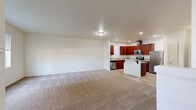 This two-story home offers a well-organized layout spread across two floors, providing ample living space for everyday comfort. The main floor features an open-concept kitchen and living area, where warm-toned carpet flows through the generous living room and transitions to tile flooring in the kitchen. The kitchen is equipped with rich cherry wood cabinetry, stainless steel appliances including a refrigerator, range, microwave, and dishwasher, complemented by tile countertops and a central island with a breakfast bar. The main floor also includes an attached garage with an automatic opener and drywalled walls.

The upper floor hosts all three bedrooms, four bathrooms, a dedicated laundry room, and three closets. The spacious primary bedroom features plush carpeting and its own walk-in closet with wire shelving. Additional bedrooms are carpeted and receive natural light through large windows with outdoor views of surrounding greenery. The laundry room is equipped with a full-size washer and dryer and tile flooring. The bathrooms feature cherry wood vanities with stone-look countertops, tile flooring, and tub-shower combinations. A hallway connects the upper-floor rooms, completing this functional and comfortable home.
