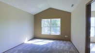 Located at 95 S Westmoor Ave in Newark, Ohio, this single-floor home offers a clean and comfortable layout with notable architectural character. The interior is highlighted by impressive vaulted ceilings that rise to a dramatic peak, creating an open and airy atmosphere that enhances the overall sense of space. Neutral-toned walls in a warm beige palette complement the soft, plush carpeting underfoot, contributing to a calm and inviting ambiance throughout. A large multi-pane window serves as a focal point, drawing in abundant natural light and offering pleasant views of the surrounding mature trees and greenery outside. The bright, sunlit interior is further accentuated by the angled ceiling lines that add architectural depth and dimension. Ceiling vents are integrated discreetly into the design, ensuring comfort without interrupting the visual flow of the space. The overall aesthetic is understated and versatile, providing a neutral canvas well-suited for a variety of interior styles. This home combines practical single-floor living with thoughtful design elements that make it feel both spacious and welcoming.