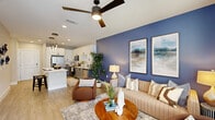 This single-story residence in Sanford, FL offers a thoughtfully designed layout encompassing one bedroom, one bathroom, a combined kitchen and living area, and a dedicated closet. The open-concept kitchen and living room serve as the heart of the home, featuring light wood-style flooring that flows seamlessly throughout. The kitchen is equipped with stainless steel appliances, two-tone cabinetry — white upper cabinets paired with grey lower cabinets — quartz countertops, and a central island with pendant lighting overhead, ideal for both meal prep and casual dining. The living area features a bold accent wall, ceiling fan, and large windows dressed with blinds and drapes that allow generous natural light to fill the space. The generously sized primary bedroom showcases a soft teal accent wall, plush carpeting, a ceiling fan, and windows that frame outdoor greenery. The bathroom is finished with dual undermount sinks set in quartz countertops, grey cabinetry with matte black hardware, a large framed mirror, and a glass-enclosed walk-in shower with marble-style tile surround. A dedicated closet provides additional storage. The overall aesthetic is modern and cohesive, with neutral tones and contemporary finishes throughout.