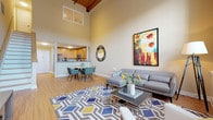 Located at 607 Norwich Ave in Norwich, Connecticut, this two-floor residence offers a thoughtfully designed layout with standout architectural details throughout. The main living area immediately impresses with its dramatic vaulted ceiling finished in warm wood, creating a sense of generous vertical space. Large windows flood the room with natural light, while light hardwood flooring runs consistently throughout the home, tying each space together seamlessly.

The open-concept design connects the living room to a dedicated dining area and kitchen. The kitchen is well-appointed with warm wood cabinetry, granite-style countertops, and a full suite of stainless steel appliances, including a refrigerator, electric range, and built-in microwave. A pass-through opening enhances the connection between the kitchen and the main living area.

The primary bedroom is a calm, well-proportioned retreat, complemented by a spacious bathroom featuring a dual-sink vanity with wood cabinetry and granite countertops. A second full bathroom includes a tub-shower combination. The second bedroom, located on the lower level, offers a more intimate setting with its own window and ample space.

Throughout the home, warm neutral tones on the walls provide a clean, inviting backdrop, and consistent hardwood-style flooring reinforces a cohesive aesthetic from room to room.