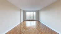 Located at 3000 Victoria Park Ave in Toronto's North York area, this well-appointed two-bedroom, two-bathroom unit offers a practical and comfortable layout across a single floor. The open-concept living and kitchen area forms the heart of the space, featuring polished parquet hardwood flooring that extends throughout the main living areas, adding warmth and character. A large sliding glass door floods the living room with natural light and provides direct access to a private balcony with outdoor views.

The kitchen is thoughtfully designed with white cabinetry, dark granite countertops, a subway tile backsplash, stainless steel appliances, and light tile flooring — offering both functionality and style. A pass-through counter connects the kitchen to the adjacent dining and living area for ease of use.

Both bedrooms are generously proportioned, featuring the same gleaming parquet floors and neutral tones. The primary bedroom includes built-in closet space, while an additional closet area provides ample storage. Two full bathrooms serve the unit, one featuring a classic white tile surround with a tub-shower combination and a crisp black accent border. Clean, neutral finishes throughout the unit create a bright and move-in ready atmosphere.