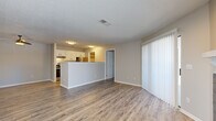 Located at 4056 Westmeadow Dr in Colorado Springs, CO, this single-floor residence offers a well-planned, open-concept layout designed for functional and comfortable living. The main living area features durable wood-style laminate flooring, neutral wall tones, and a textured ceiling throughout. A standout feature of the living room is the dark-tiled fireplace with a white mantel, flanked by windows and a sliding glass door that opens to a private patio, filling the space with natural light. The kitchen is outfitted with white cabinetry, stainless steel appliances including a refrigerator and range, and a peninsula that connects seamlessly to the open living and dining areas. Bedrooms are carpeted for warmth and comfort, each offering closet storage and natural light from window coverings. The bathroom includes a full tub and shower combination with white tile surround and updated fixtures. A dedicated in-unit laundry area accommodates a full-size washer and dryer side by side, with overhead shelving for added storage. The thoughtful layout and clean finishes make this a practical and inviting home in a residential Colorado Springs neighborhood.